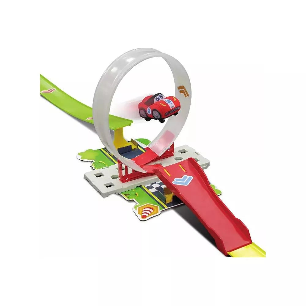 A small red toy car zooms through a plastic loop on the vibrant Maisto My 1st Soft Touch Loop Set racetrack, a colorful toddler racing playset featuring a green ramp and red launcher.