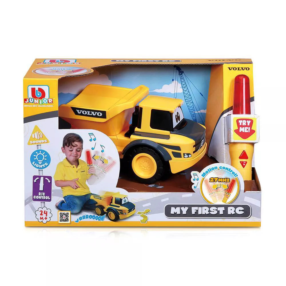 Boxed Maisto My First RC Volvo Dump Truck in yellow, labeled “VOLVO,” includes a remote controller; packaging highlights features and shows a child playing with the R/C truck from the My First RC series.