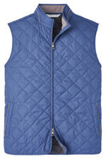 The Peter Millar Essex Quilted Travel Vest is a blue, sleeveless men's vest featuring windproof fabric, a full-zip front, and two concealed pockets on either side.