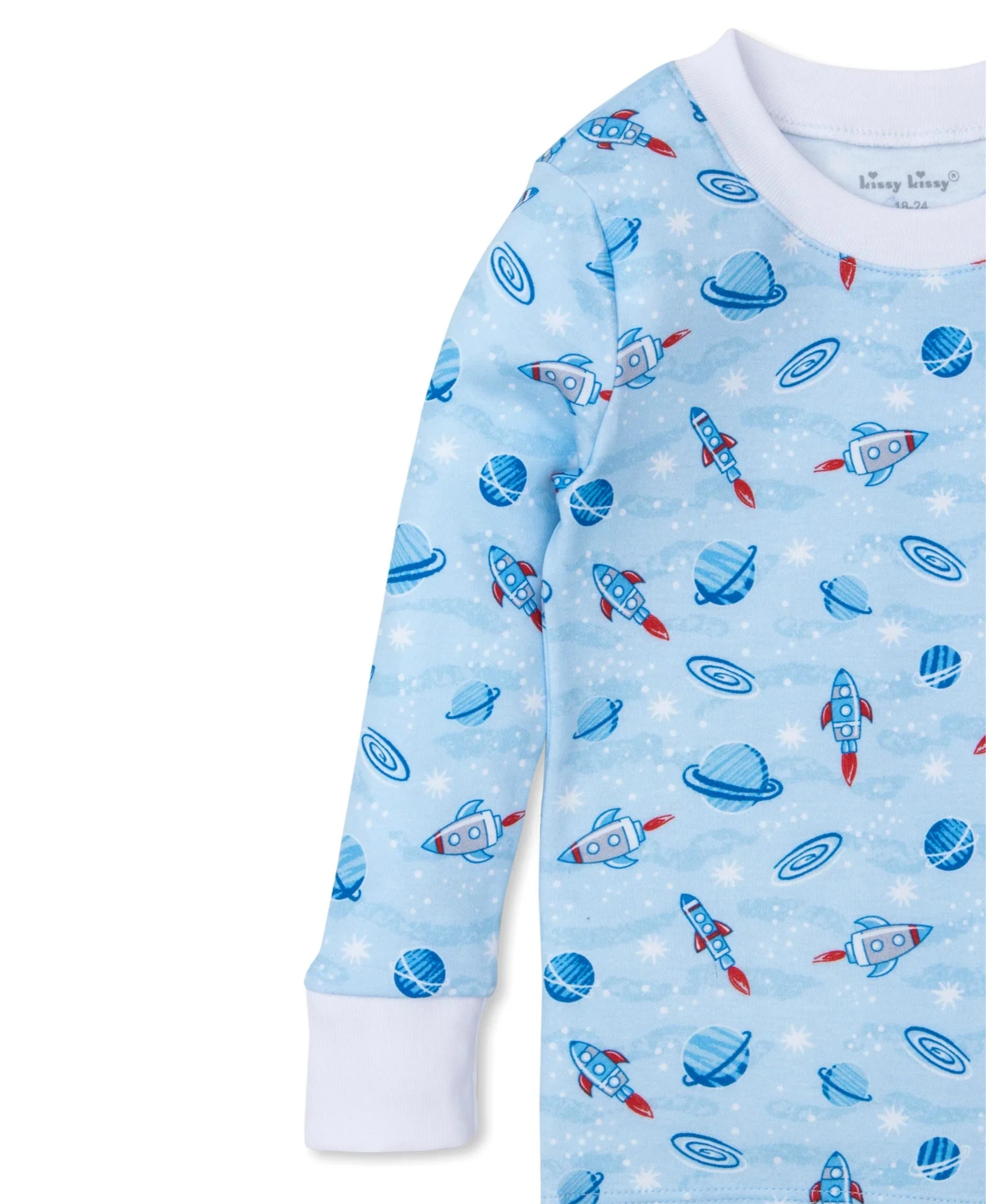 The Kissy Kissy Galaxy Printed PJ Set is a light blue pajama set for children with a space theme, showcasing red and blue rockets, planets, and stars. Made from soft Pima cotton, it features white cuffs.