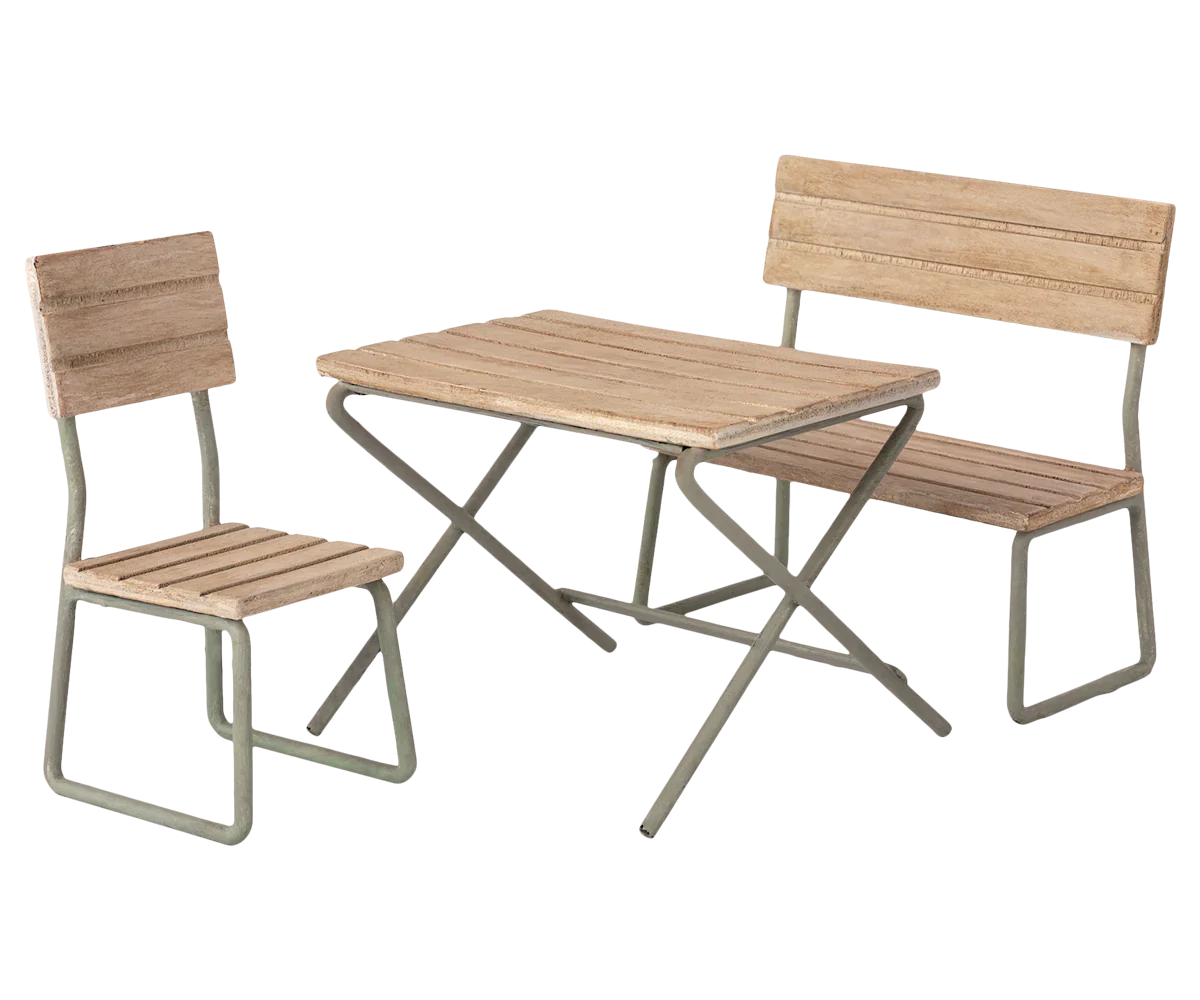 The **Maileg Garden Set, Miniature** by **Maileg** features a vintage design with a wooden table, bench, and chair all supported by metal frames. This elegant patio furniture set is perfect for enhancing any outdoor space and is made from FSC wood.