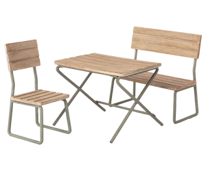 The **Maileg Garden Set, Miniature** by **Maileg** features a vintage design with a wooden table, bench, and chair all supported by metal frames. This elegant patio furniture set is perfect for enhancing any outdoor space and is made from FSC wood.