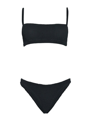 The Hunza G Gigi Bikini is a black crinkle fabric two-piece with a straight bandeau top, thin straps, and matching high-cut bottoms, shown on a white background. This one-size swimsuit blends comfort and modern style.