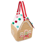 The Meri Meri Gingerbread House Bag, featuring red and white striped handles and adorned with colorful pom-poms and candy cane details, is the perfect festive accessory to celebrate the season.