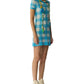 A woman in a blue and white Guest in Residence Gingham Polo Dress, beige high-top sneakers, and a long colorful necklace stands against a plain white background.