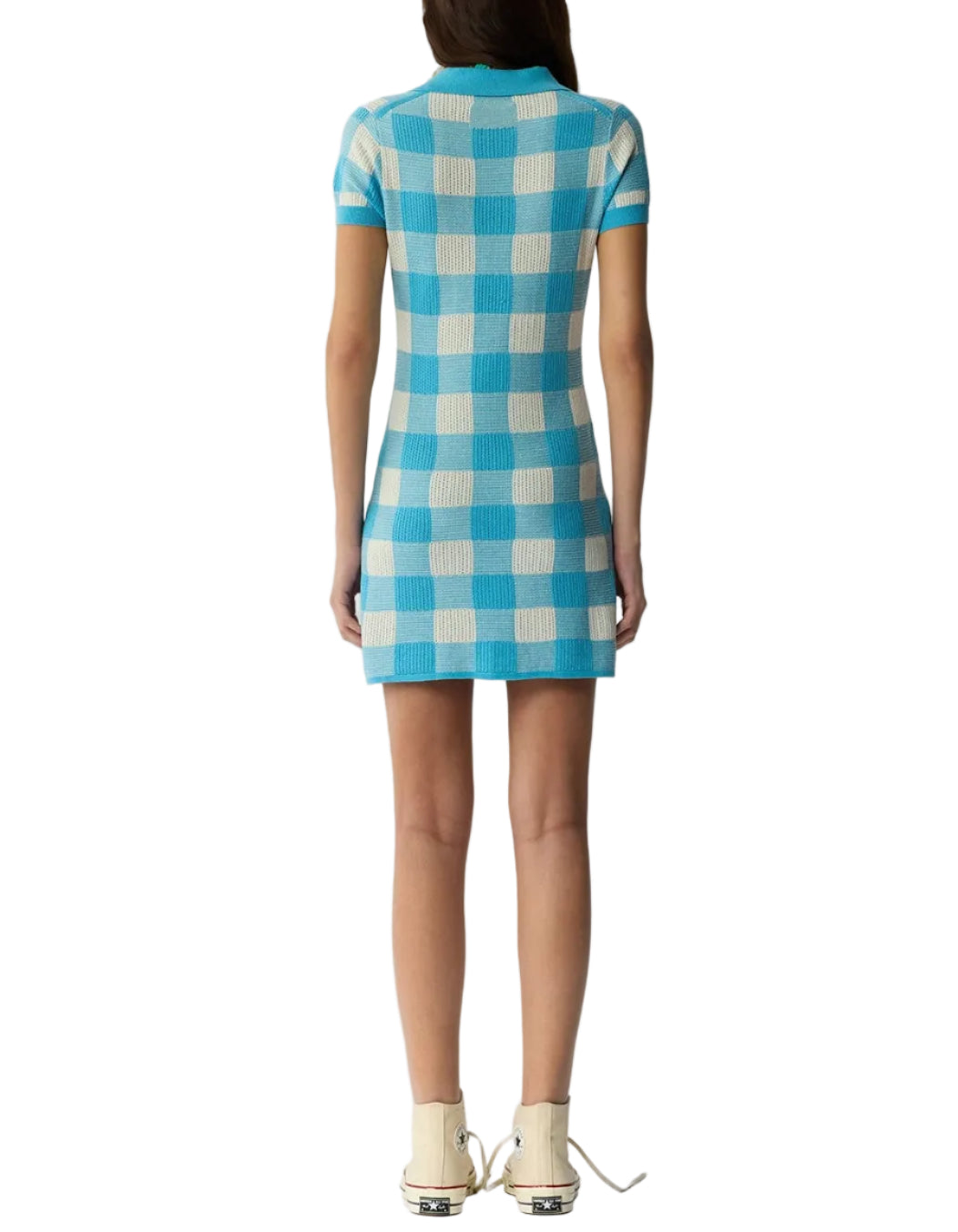 A person stands facing away, wearing the Guest in Residence Gingham Polo Dress in blue and white with short sleeves and beige lace-up shoes.