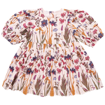 The Pink Chicken Girls' Brooke Dress from Pink Chicken is a long-sleeve, floral-printed dress for children, featuring a gathered waist and glitter button back closure, adorned with a mix of pink, blue, and green patterns on a white background.