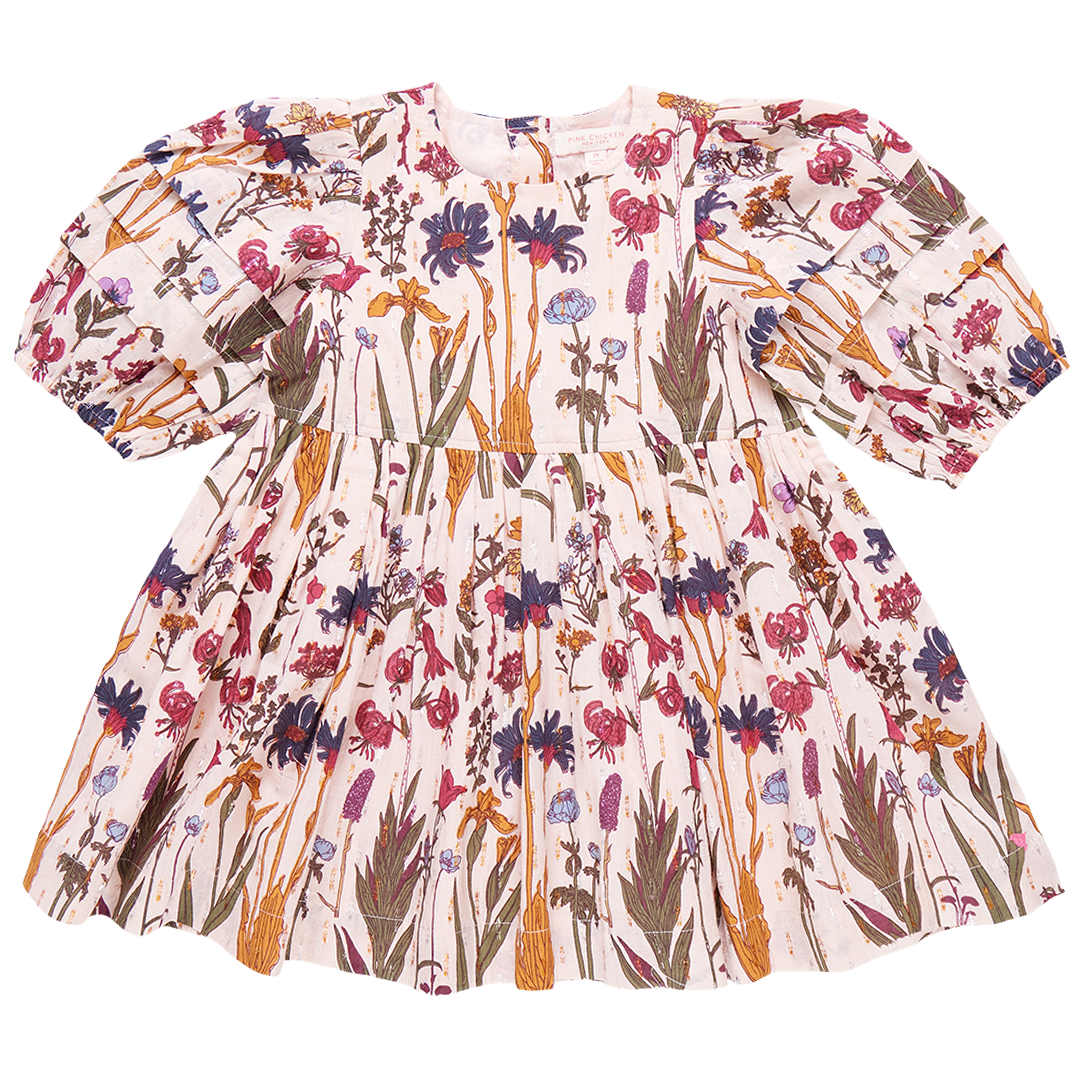 The Pink Chicken Girls' Brooke Dress from Pink Chicken is a long-sleeve, floral-printed dress for children, featuring a gathered waist and glitter button back closure, adorned with a mix of pink, blue, and green patterns on a white background.