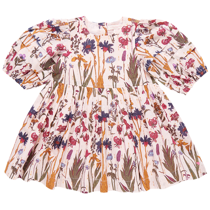 The Pink Chicken Girls' Brooke Dress from Pink Chicken is a long-sleeve, floral-printed dress for children, featuring a gathered waist and glitter button back closure, adorned with a mix of pink, blue, and green patterns on a white background.