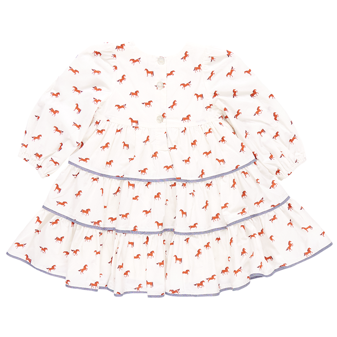 A charming Pink Chicken Girls' Julia Dress featuring long sleeves, small red horse prints, and chambray detailed tiers, perfect for an equestrian chic look.