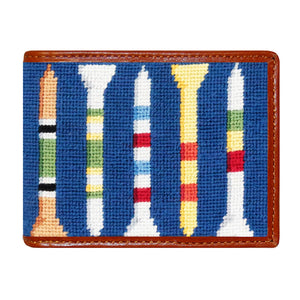 The Smathers & Branson Bi-Fold Wallet is a blue needlepoint wallet with brown leather trim, showcasing hand-stitched colorful striped golf tees arranged vertically.