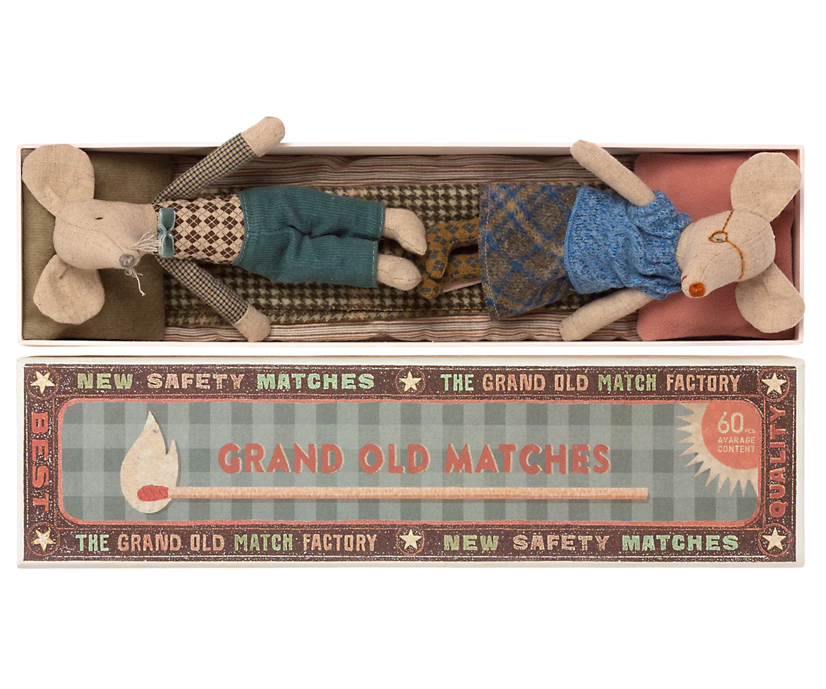 Two whimsical fabric mice, tucked comfortably in a matchbox-style package labeled "Mail Grandma & Grandpa Mice in Matchbox," make for the perfect children's toy by Maileg. Adorned with charming vintage-style design elements, these delightful grandma and grandpa mice will add a touch of nostalgic joy to any child's playtime.