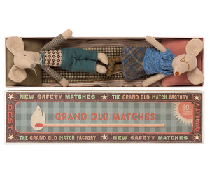 Two whimsical fabric mice, tucked comfortably in a matchbox-style package labeled "Mail Grandma & Grandpa Mice in Matchbox," make for the perfect children's toy by Maileg. Adorned with charming vintage-style design elements, these delightful grandma and grandpa mice will add a touch of nostalgic joy to any child's playtime.