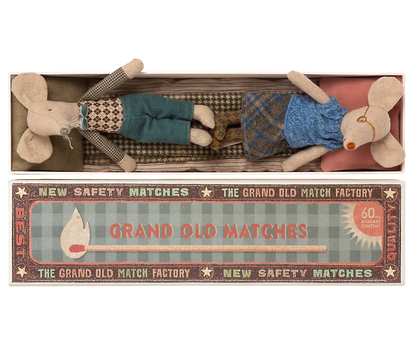 Two whimsical fabric mice, tucked comfortably in a matchbox-style package labeled "Mail Grandma & Grandpa Mice in Matchbox," make for the perfect children's toy by Maileg. Adorned with charming vintage-style design elements, these delightful grandma and grandpa mice will add a touch of nostalgic joy to any child's playtime.