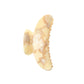 The Machete Grande Heirloom Claw, shown against a white background, is a beige and light brown marbled hair clip made from premium Italian acetate, featuring curved edges and interlocking teeth for a secure hold on long, thick, or voluminous hair.