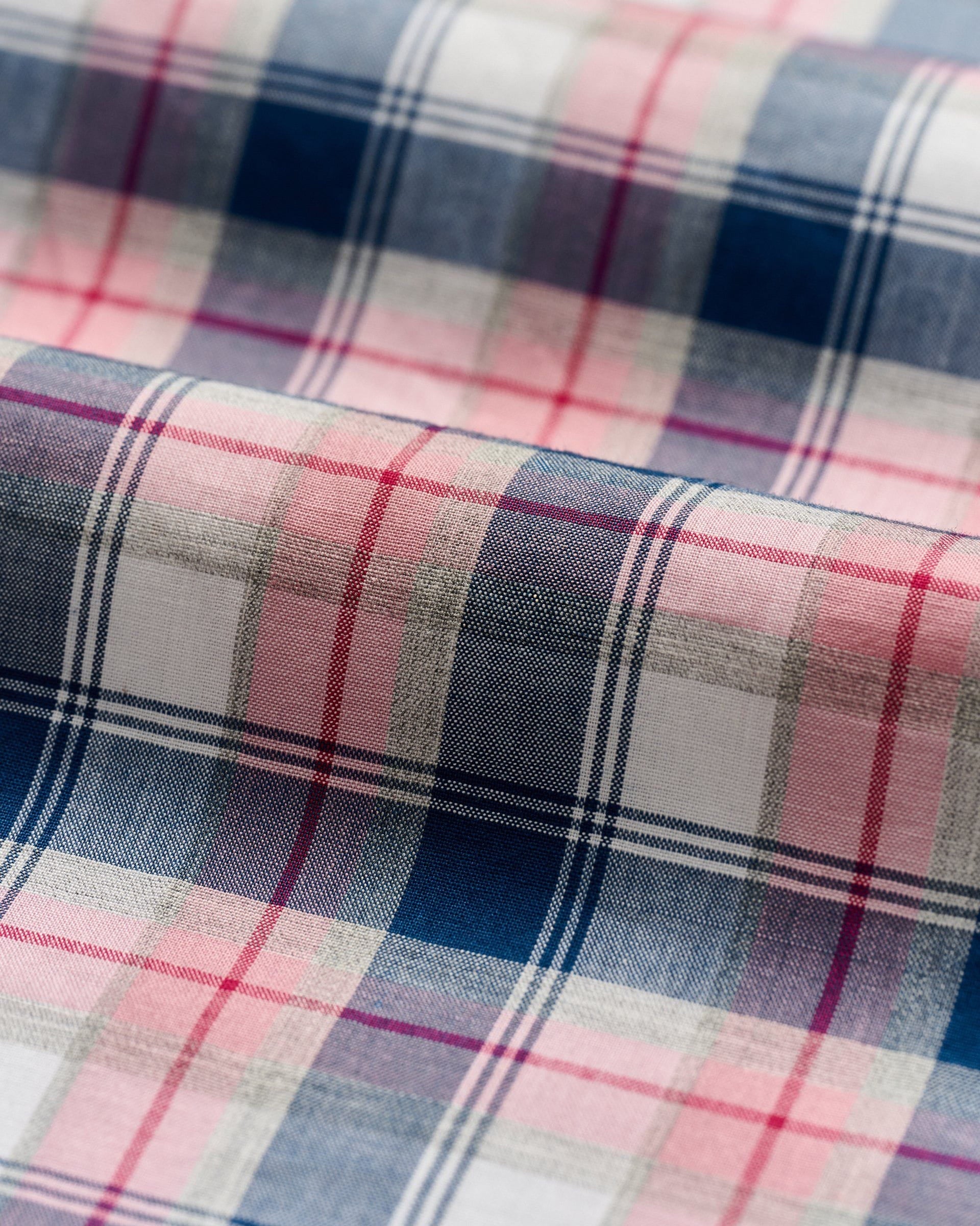 Close-up of the Johnnie-O Granger Button Down by Johnnie-O, showcasing ultra-premium plaid fabric with red, blue, and white stripes in luxe cotton gently folded.