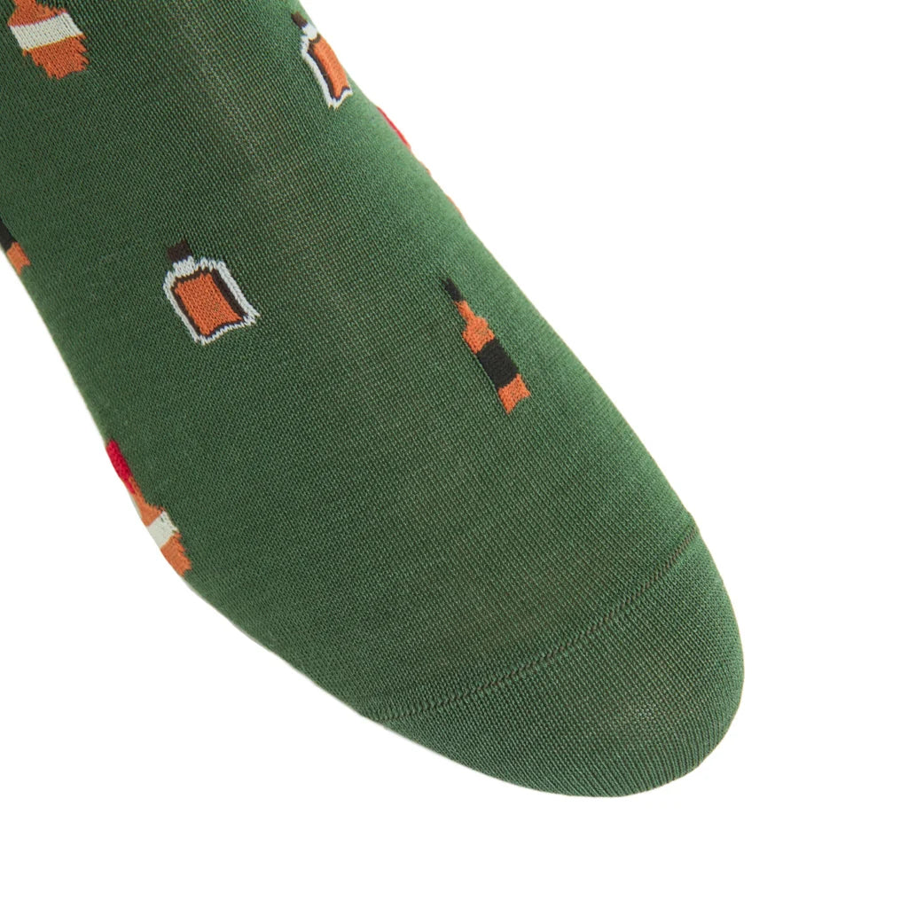 A close-up of the toe of the Pine Green Bourbon Bottles Mid Calf Sock by Dapper Classics, featuring a breathable fabric with small embroidered bourbon bottles and mugs, shown on a white background.