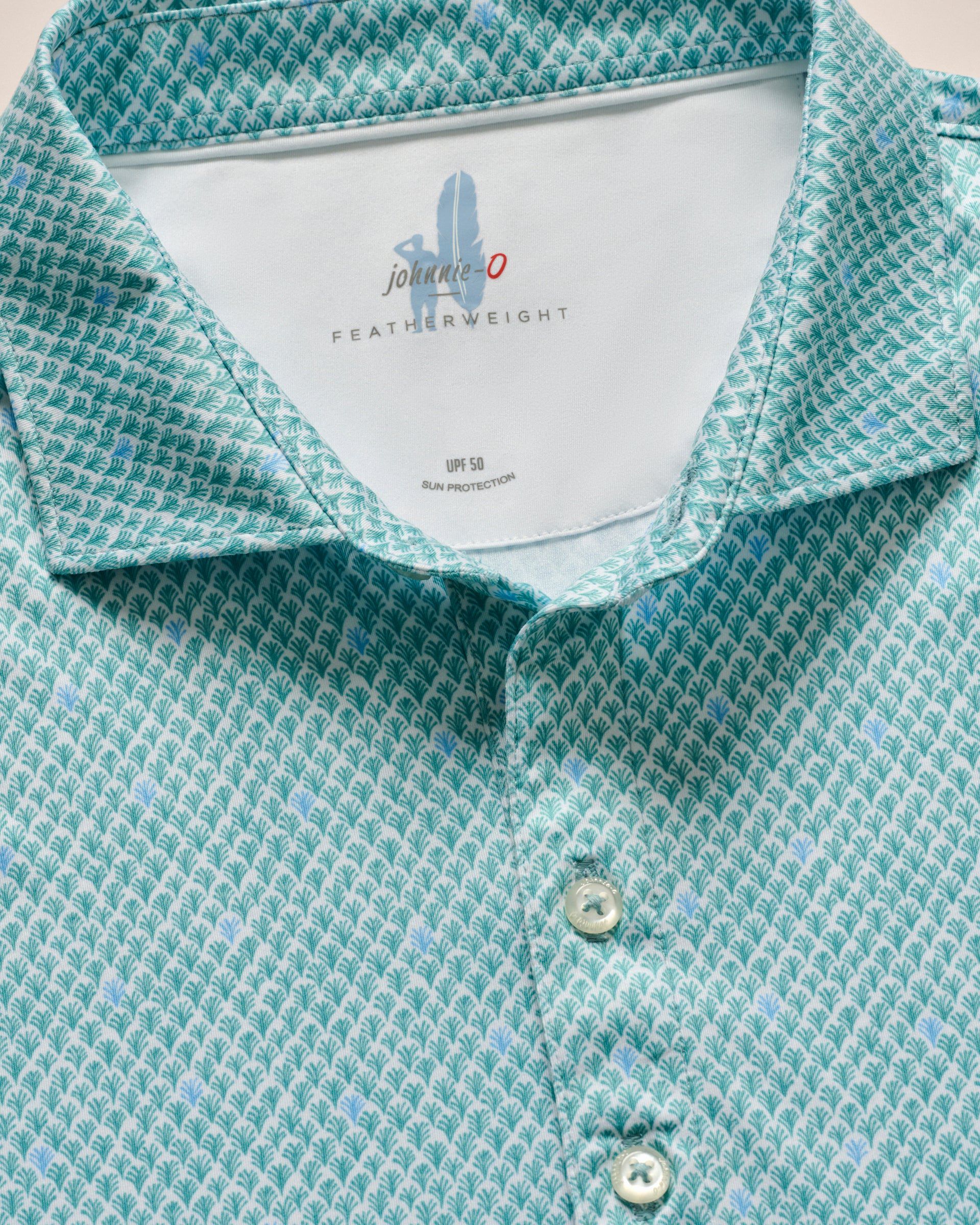 The Johnnie-O Featherweight Performance Fernando Polo, in turquoise with white buttons and a "johnnie-O" label, offers UPF 50 protection. Crafted with featherweight fabric, it combines the functionality of performance polos with a stylish design.