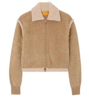 The Grizzly Frankie Jacket by Guest in Residence is a tan cropped cashmere jacket with a wide shearling collar, textured body, ribbed cuffs, and a front zipper.