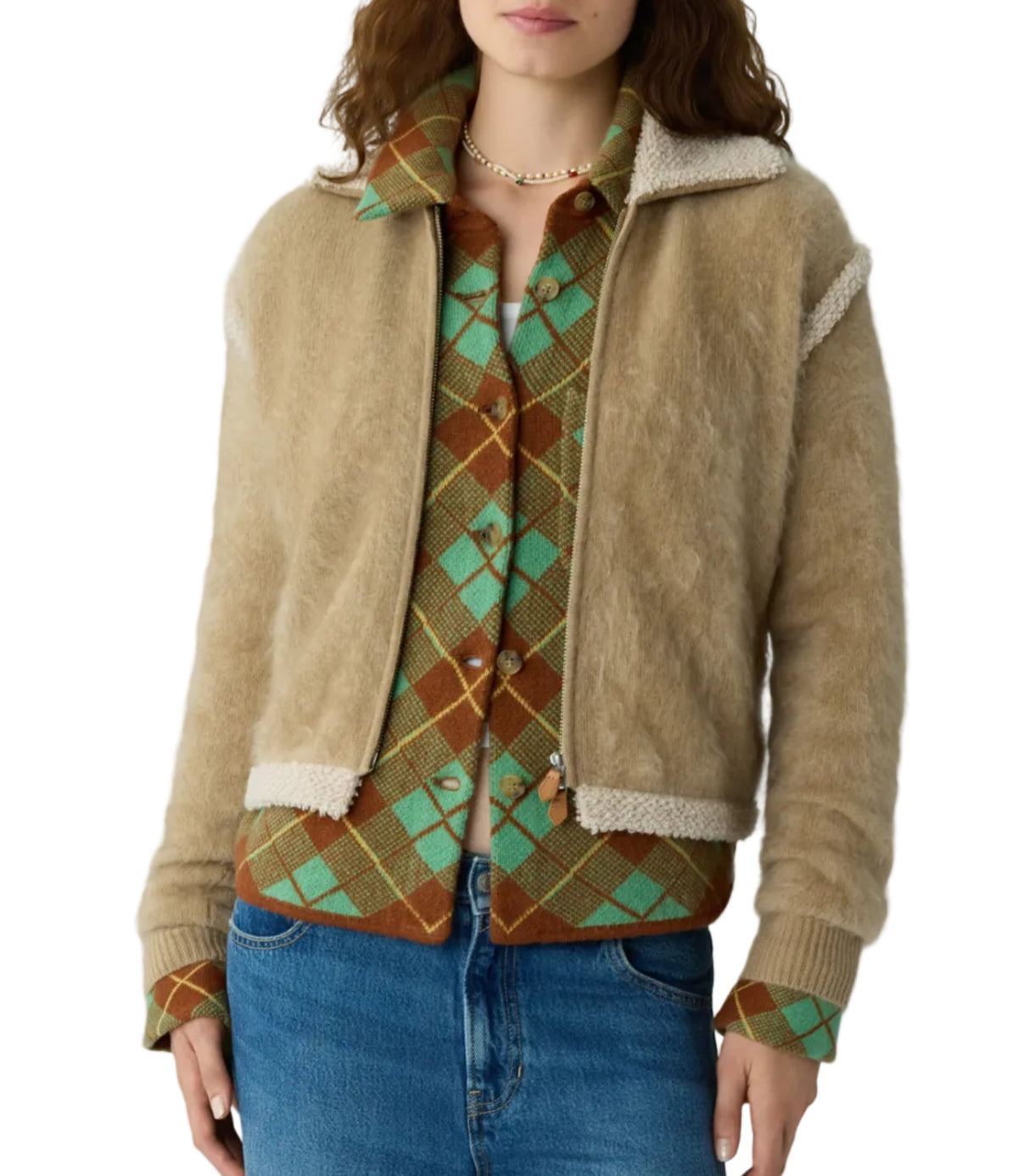 A person wears the Grizzly Frankie Jacket by Guest in Residence over a green and brown argyle sweater with blue jeans, shown from chest to hips.