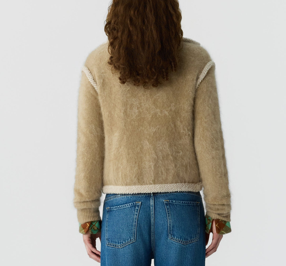 Person with long curly hair, wearing the Guest in Residence Grizzly Frankie Jacket and blue jeans, shown from the back against a plain light background.