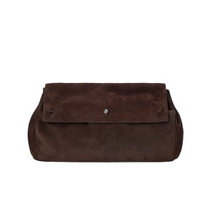 The Cy Oversized Bag by Staud is a rectangular, dark brown suede clutch featuring a fold-over flap, subtle silver hardware at the center, and a long drop strap for versatile styling.