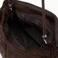 Close-up of the interior of the Staud Cy Oversized Bag in brown suede, featuring a zippered pocket, fabric lining, and two leather handles secured with metal hardware—a statement piece designed for both style and function.