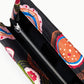 Close-up of the Staud Muse Beaded Clutch, an open black evening clutch adorned with a vibrant floral beaded pattern. It features a silver zipper pocket and black fabric lining inside, making this compact silhouette the perfect accessory for any special occasion.