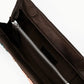 Open brown Staud Muse Clutch shown from above, revealing a zippered interior pocket and snap closures on the flap—an ideal evening accessory to complement your favorite occasion dresses.