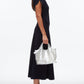 A woman in a black short-sleeve midi dress and black flats holds the 3.1 Phillip Lim Mesh Sequin Mini Market Tote, standing in profile against a plain white background.