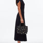 A woman in a black midi dress and flats stands in profile, holding the 3.1 Phillip Lim Washed Denim Mini Market Tote.