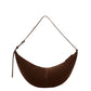 The Proenza Schouler Slide Suede Bag features a curved silhouette, adjustable strap, and brown suede design. Shown crescent-shaped against a plain white background.