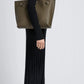 A person in a black ribbed turtleneck dress and black boots stands in profile, carrying the Proenza Schouler Days Pebbled Calf Skin Tote on their shoulder.