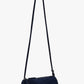 The Silo Crossbody Bag by Proenza Schouler, in dark blue suede with a long adjustable strap and zipper closure, is shown against a plain light background.