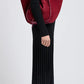 A person in a black long-sleeve pleated dress and black boots stands sideways, carrying a Proenza Schouler Large Ruched Soft Suede Tote with a gold-tone logo on their shoulder against a plain background.