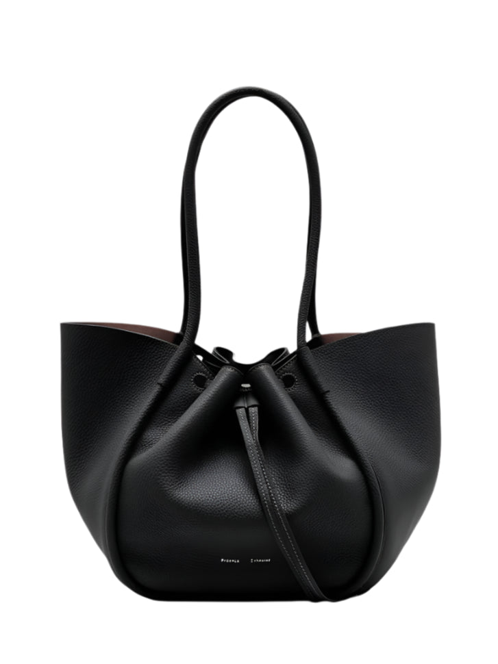 The Proenza Schouler Large Ruched Soft Pebbled Calf Tote is a black pebbled leather bag with two handles, a drawstring closure, and a detachable leather zip pouch.
