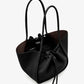 The Large Ruched Soft Pebbled Calf Tote by Proenza Schouler is a black bucket bag with two shoulder straps and a drawstring closure, featuring a roomy interior—an ideal match for your favorite leather zip pouch.