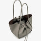 The Proenza Schouler Large Ruched Soft Pebbled Calf Tote in grey features double handles, a drawstring closure, and an inner leather zip pouch, displayed against a plain white background.