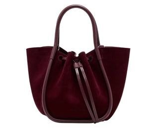 The Proenza Schouler Small Ruched Soft Suede Tote features burgundy suede, smooth leather trim, a drawstring closure, dual handles, and a sculptural silhouette.