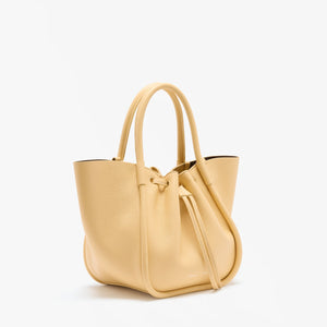 The Proenza Schouler Small Ruched Soft Pebbled Calf Tote in light yellow features double handles, a ruched open top, and a drawstring closure, shown against a plain white background.