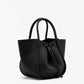 The Proenza Schouler Small Ruched Soft Pebbled Calf Tote in black leather features two handles, a drawstring closure, and a sculptural silhouette, displayed against a plain white background.