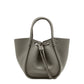 The Proenza Schouler Small Ruched Soft Pebbled Calf Tote in gray leather features a sculptural silhouette, drawstring closure, and double handles, displayed against a plain white background.