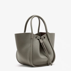 The Proenza Schouler Small Ruched Soft Pebbled Calf Tote is a textured gray leather bag with two handles and a ruched drawstring open top, shown against a white background.