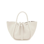 The Proenza Schouler Small Ruched Soft Pebbled Calf Tote is a white leather bucket bag with a sculptural silhouette, two handles, and a ruched drawstring top, shown against a plain white background.
