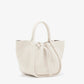 The Proenza Schouler Small Ruched Soft Pebbled Calf Tote in white leather features a sculptural silhouette, two handles, and a ruched open top with drawstring closure, shown against a plain white background.