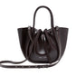 The Proenza Schouler Small Ruched Soft Shiny Tote in dark brown leather features a sculptural silhouette, a drawstring closure, double handles, and an adjustable shoulder strap, showcased against a white background.