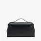 The Proenza Schouler Tate Clutch is a structured black leather bag featuring a top handle, silver hardware, and a flap closure. This compact accessory is shown against a plain white background.
