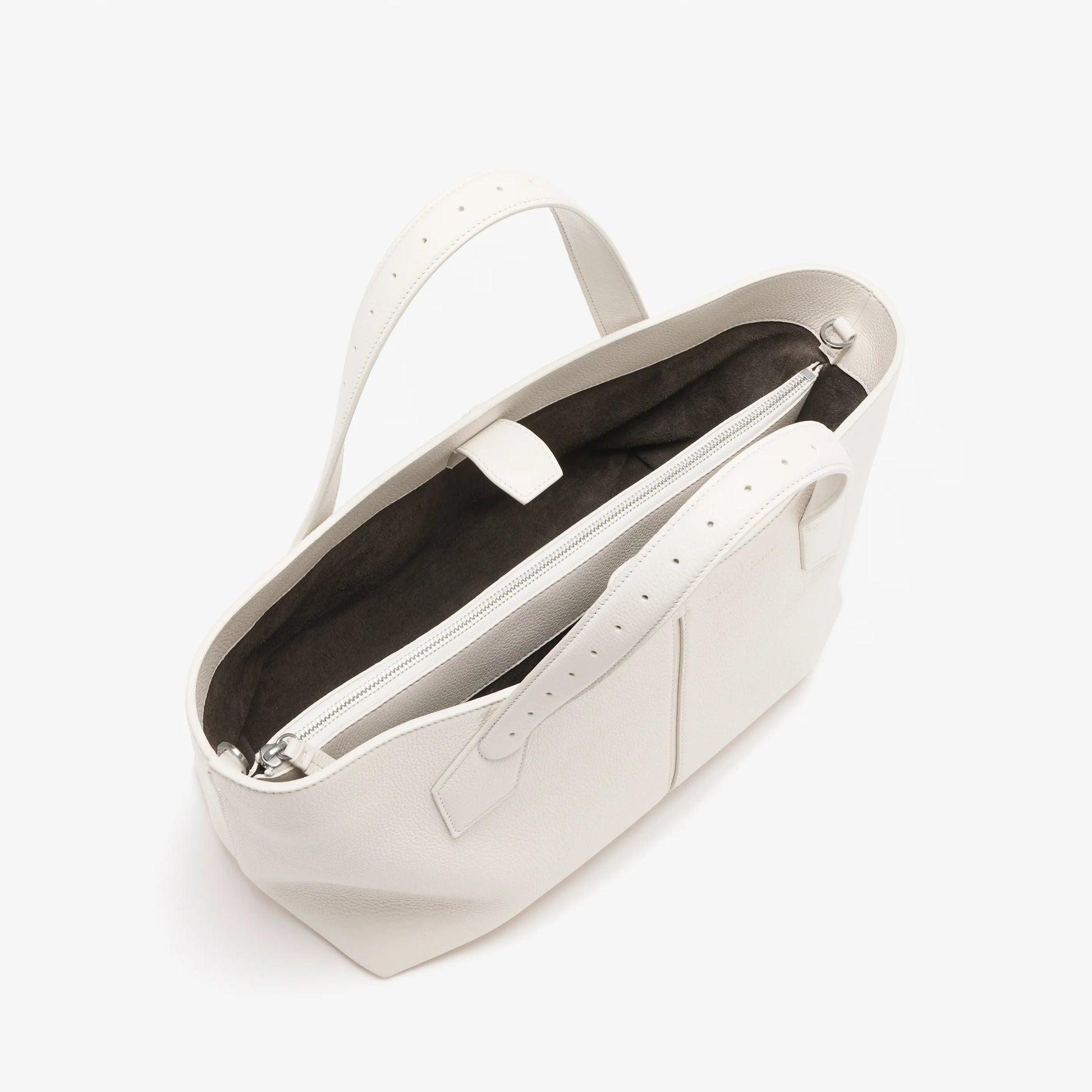 The East West Chelsea Tote by Proenza Schouler features a structured silhouette in white pebbled calf leather with dual handles, an open top, dark lining, and an interior zip pocket.