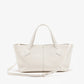 The Proenza Schouler East West Chelsea Tote in white pebbled calf leather features double handles, a detachable shoulder strap, and a structured silhouette, shown against a plain white background.