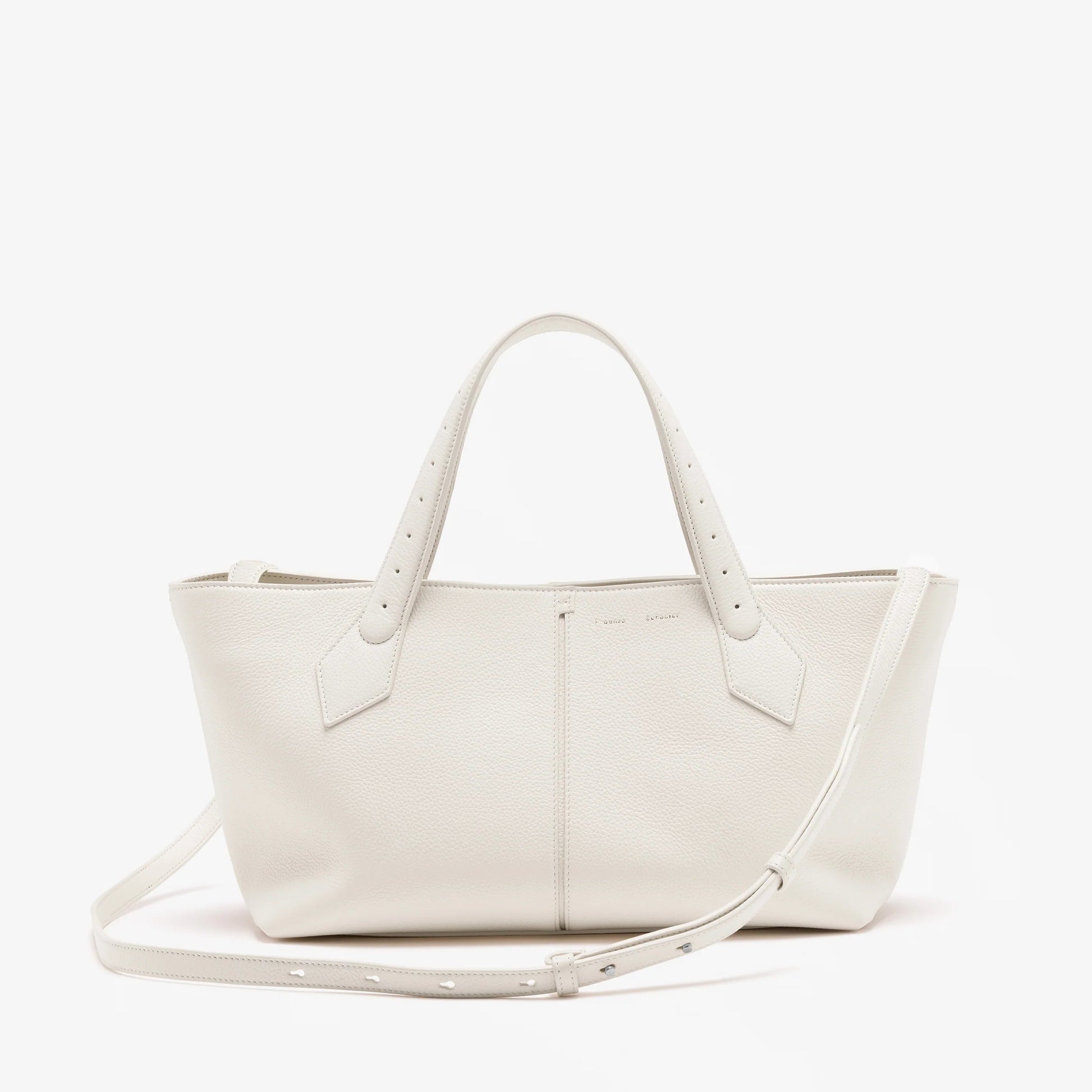 The Proenza Schouler East West Chelsea Tote in white pebbled calf leather features double handles, a detachable shoulder strap, and a structured silhouette, shown against a plain white background.